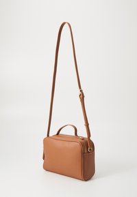 Sac bandoulière en cuir marron avec une finition texturée, une poignée supérieure et une bandoulière ajustable. Il présente une fermeture à glissière et une forme rectangulaire.