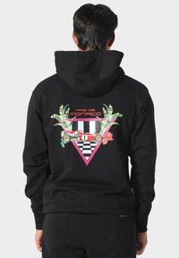 Felpa nera con cappuccio caratterizzata da una grafica vivace sul retro, con foglie di palma, una macchina da corsa, accenti floreali e un design triangolare.