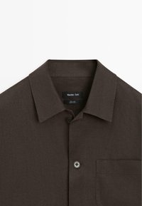 Ciemnobrązowa lniana koszula z kołnierzykiem, guzikami z przodu oraz kieszenią na piersi, z metką Massimo Dutti wewnątrz kołnierza.