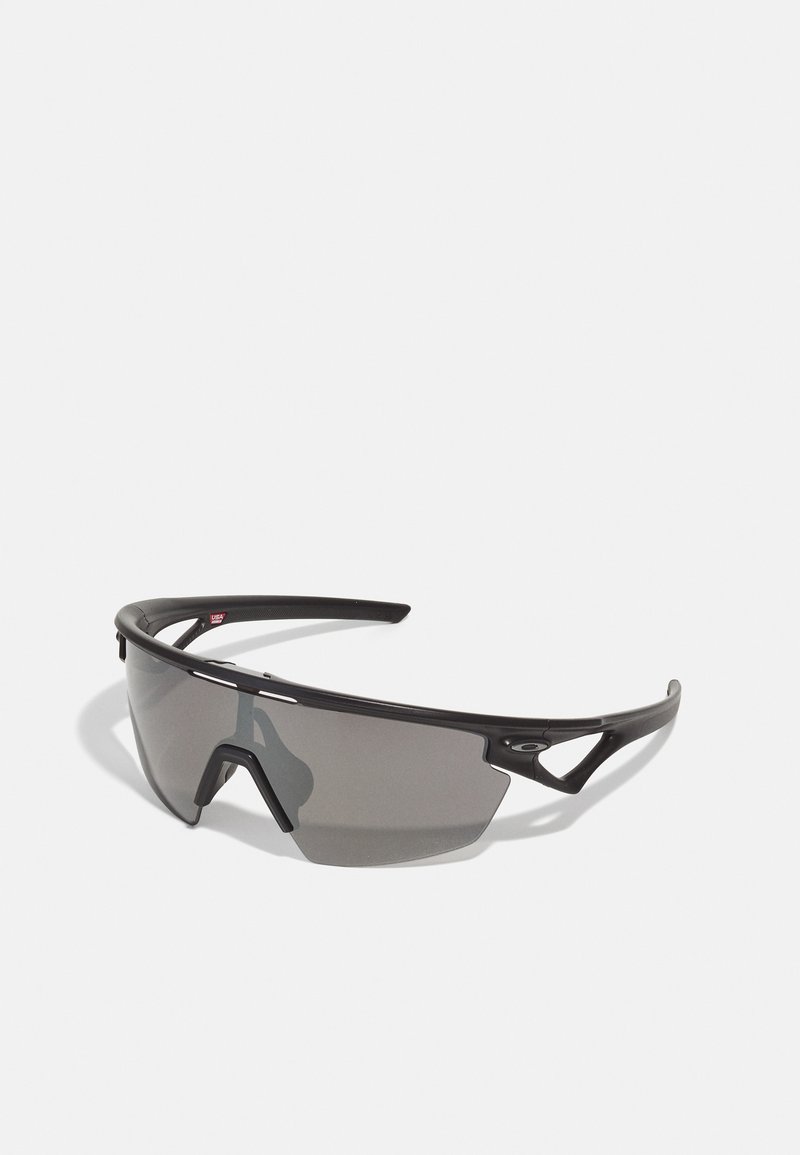 Sportsonnenbrille mit schwarzem Rahmen, grauen Gläsern, aerodynamischem Design und kantiger Form; verfügt über betonte Bügel und Nasenbrücke.