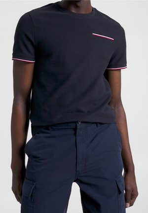 Navy cotton t-shirt with short sleeves, textured fabric, red and white striped accents on cuffs and chest pocket, front-centered design.