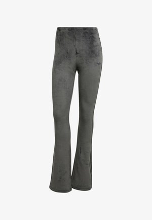 Grå ribbade utsvängda byxor i mjukt tyg med en subtil textur; har hög midja och ett svagt urblekt mönster på benen.