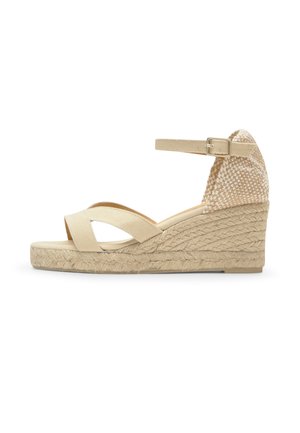 Beige sleehak sandaal met enkelriem, gekruiste voorbanden en een gevlochten espadrille stijl plateauzool.