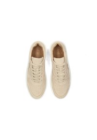 Zapatillas beige con parte superior suave y texturizada, punta redondeada y detalles perforados. Suela de goma blanca y cordones a tono. Logo estampado en la plantilla.
