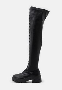 Czarne kozaki za kolano wykonane z gładkiej skóry, z masywną podeszwą platformową i bocznym sznurowaniem z metalowymi oczkami.