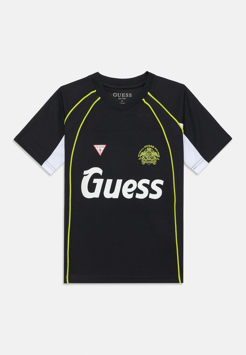 Melna sporta krekls ar īsām baltām piedurknēm, neona zaļiem akcentiem un lielu balto "Guess" logotipu. Izceltas trīsstūrveida emblēmas kreisajā pusē.