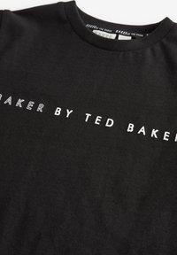 Čierne bavlnené tričko s bielym textom "BAKER BY TED BAKER." Klasický okrúhly výstrih a štandardný strih, s hladkou a jemnou textúrou.