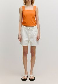 Oranje tanktop met vierkante halslijn, witte hoge taille shorts met zakken, en flip-flops met zwarte zolen en een witte band, minimalistisch ontwerp.