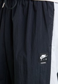 Shorts Nike Air en noir et blanc. Fabriqués en tissu léger et texturé. Dotés d'une taille élastique et d'une étiquette noire avec logo.