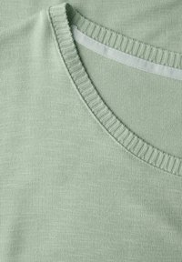 Lichtgroene T-shirt met korte mouwen, voorzien van een ribbelboord en een gladde textuur. Heeft een eenvoudig ontwerp zonder patronen of versieringen.