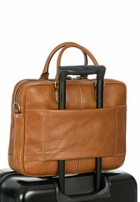 Lederakte in sattem Braun mit zwei Griffen und einer seitlichen Tasche auf der Rückseite. Positioniert auf einem schwarzen Koffer, mit sichtbaren Rollen.