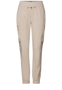 Pantalons cargo beiges avec une coupe décontractée, taille élastique, fermeture à cordon de serrage et plusieurs poches latérales. Matériau en coton lisse.