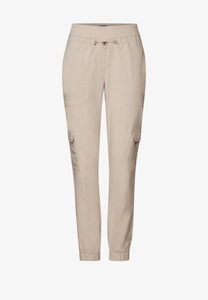 Pantaloni cargo beige con vestibilità morbida, fascia elastica in vita, chiusura con cordino e numerose tasche laterali. Materiale in cotone liscio.