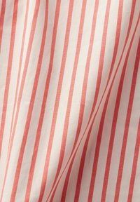 Tessuto di cotone con strisce verticali alternate di colore rosso e bianco, caratterizzato da una consistenza morbida e una finitura liscia.