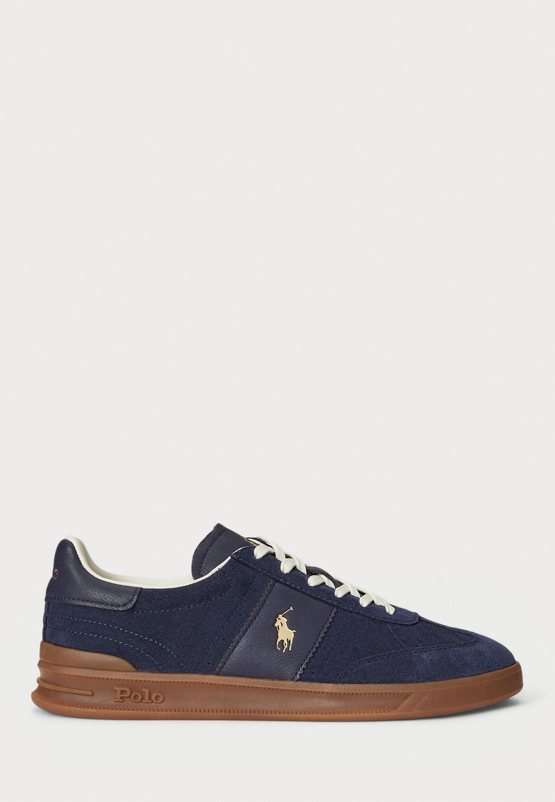 Navy blue suede sneaker with white laces, brown rubber sole, and gold Polo logo on the side, displayed on a white background.