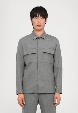 Gray button-up jacket with a collar, two chest pockets, a textured fabric, and long sleeves, paired with matching pants.