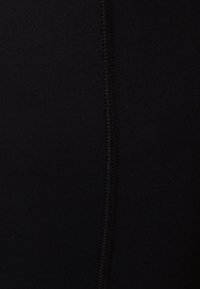 Tissu extensible noir à texture lisse, avec une couture centrale et des surpiqûres contrastantes le long de la longueur. Pas de motifs ni d'accents supplémentaires.