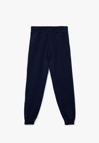 Mørkeblå joggingbukser med ribbet talje, elastiske manchetter og sidelommer. Fremstillet af blødt, strækbart stof.