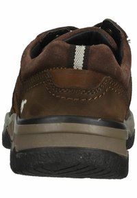 Scarpe in suede marrone con suola in gomma nera, caratterizzate da un accento a strisce bianche e dettagli cuciti. La vista posteriore mostra una forma arrotondata.