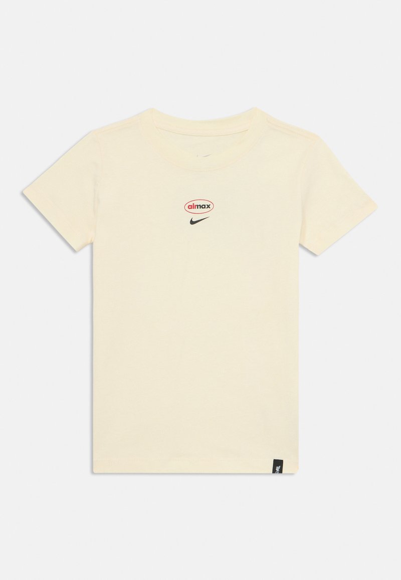 T-shirt en coton crème avec un col rond, arborant un logo "aimax" rouge et noir et un swoosh Nike noir sur le devant.