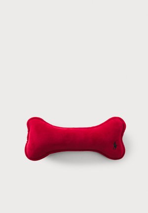 Giocattolo per cani in peluche rosso a forma di osso, caratterizzato da una texture liscia e un piccolo logo ricamato in nero su un lato.