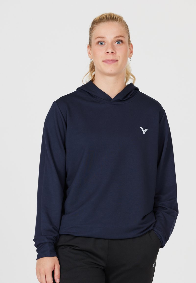 Marinblå hooded långärmad skjorta i mjukt material, med en liten silverlogotyp på bröstet och en avslappnad passform med långa ärmar.
