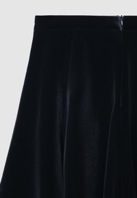 Schwarzer Samtrock mit glatter Textur, plissiertem Design und verdecktem Reißverschluss auf der Rückseite.