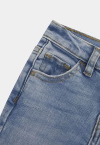 Ljusblå denimjeans med medelhög midja, med en liten framficka, synliga sömmar och en slät yta.