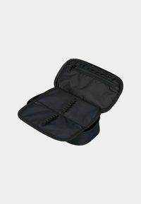 Borsa in tessuto nero con chiusura a zip, dotata di un interno aperto con bande elastiche e una piccola tasca con zip per l'organizzazione.