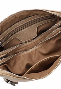 Brown leather handbag interior with multiple zippered pockets and smooth fabric lining. Features silver-tone zipper hardware.