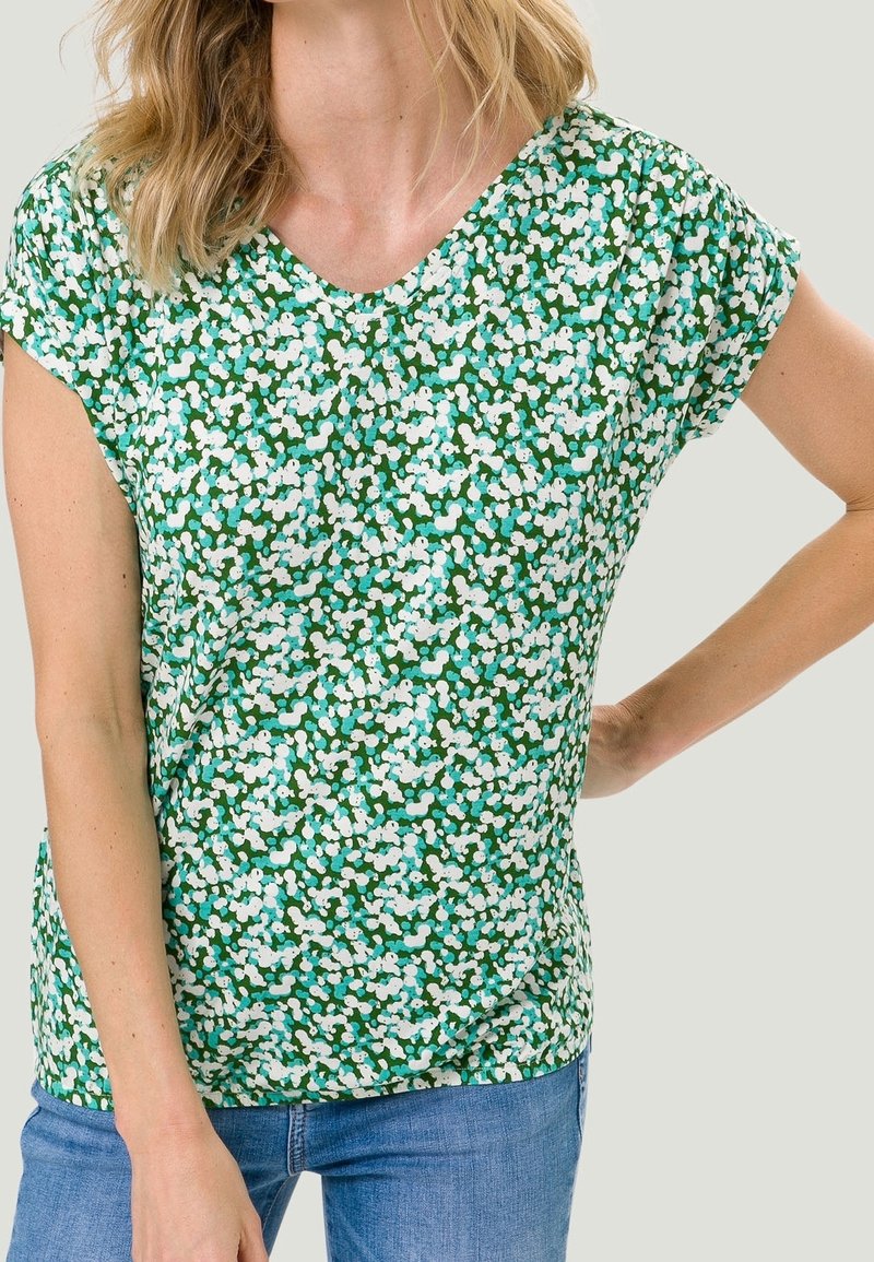 Top corto de mangas cortas con un patrón floral verde y escote en V, hecho de una tela ligera, que presenta acentos en blanco y azul y un corte relajado.