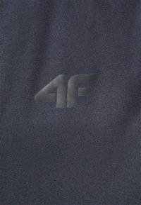 Tissu bleu marine avec une surface texturée présentant un logo noir en relief "4F" subtilement intégré dans le matériau. Design simple et moderne.