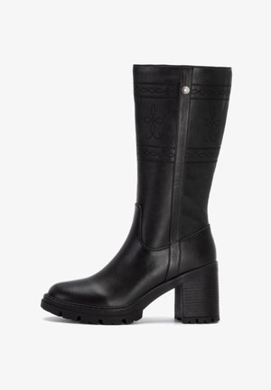 Stivale nero fino al ginocchio con tacco a blocco, realizzato in pelle liscia. Presenta motivi in rilievo e un design con pannelli laterali per un tocco di dettagli in più.