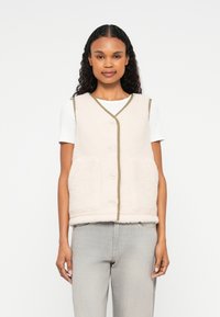 Gilet en polaire beige clair avec une surface texturée, doté d'un col en V, de quatre boutons et d'une bordure contrastante olive. Comprend deux poches avant.