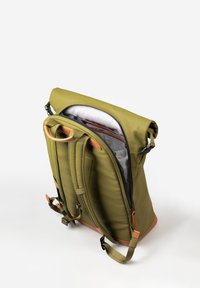 Zaino verde oliva con chiusura roll-top, spallacci imbottiti e dettagli in pelle marrone. Interno foderato con tasche organizzative e cerniere.