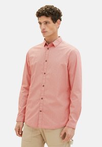 Langärmliges Hemd mit rot-weißem Muster und Button-down-Kragen, mit braunen Knöpfen und einem strukturierten Stoffdesign.
