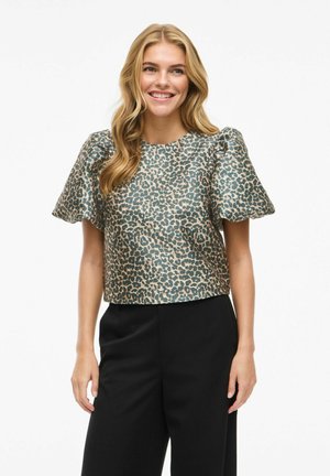 Top court en turquoise avec un imprimé léopard beige, présentant des manches bouffantes courtes et une texture lisse. Associé à un pantalon noir.