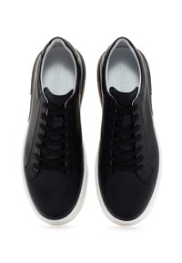 Baskets en cuir noir avec une finition lisse, semelle en caoutchouc blanc, bout rond et lacets plats. Design minimaliste avec un branding discret.