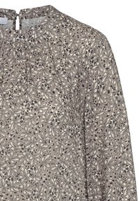Blusa floreale con collo alto, caratterizzata da uno sfondo beige e motivi a foglia in bianco e nero, con delicate pieghe sul davanti.