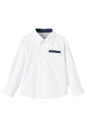 Valkoinen pitkähihainen nappikiinnitteinen paita, jossa laivastonsininen kauluksen reunus ja laivastonsinisin reunuksin koristeltu rintatasku, suunniteltu lapselle.