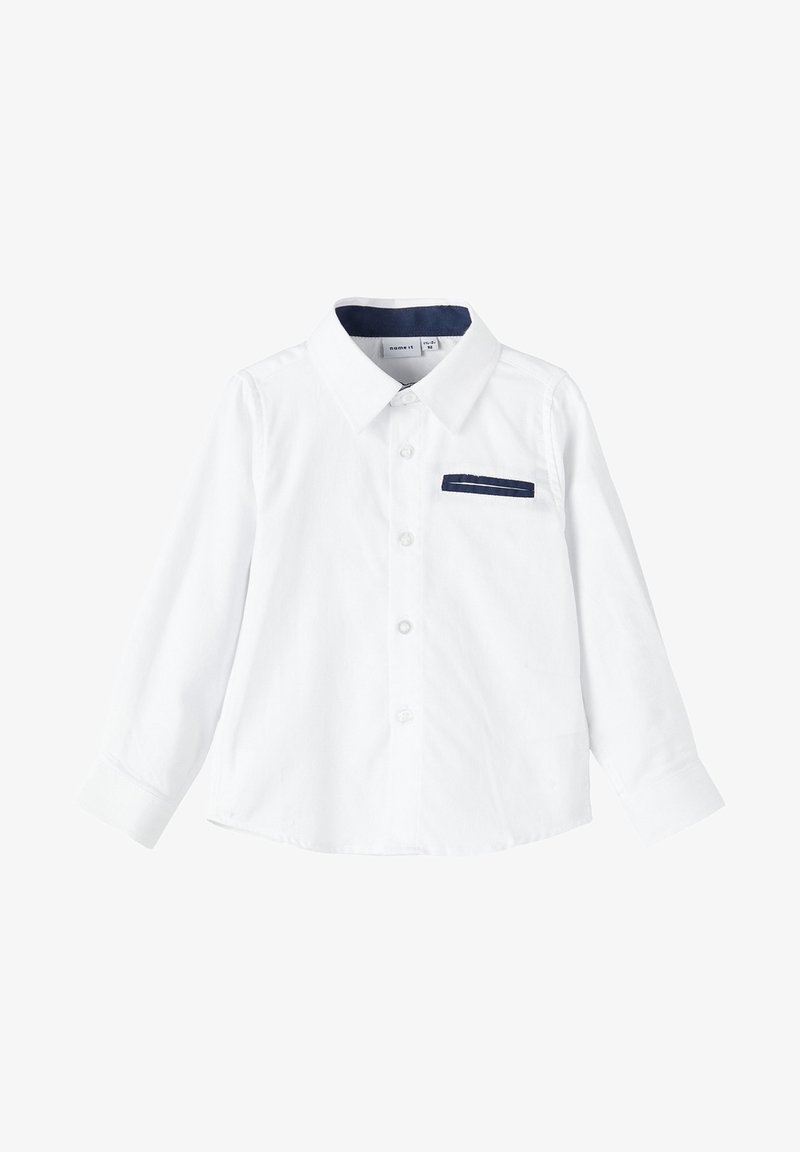 Chemise blanche à manches longues avec col et poche poitrine bordés de marine, conçue pour un enfant.