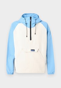 Anorak mit blauer Kapuze und Ärmeln, beiger Körper; verfügt über eine Vordertasche und schwarze Kordeln. Weicher Stoff mit elastischen Bündchen.