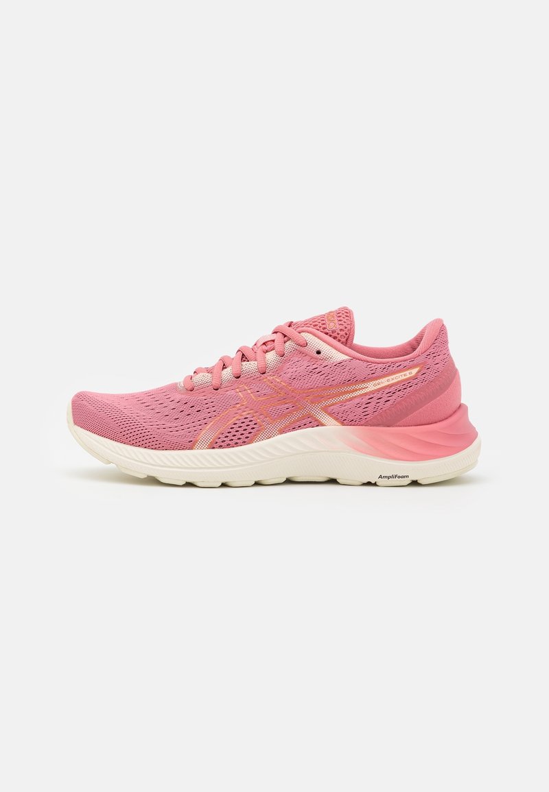 Chaussure de course en mesh rose avec semelle blanche, design à lacets, et logo orange subtil ainsi que des accents sur le côté et le talon.