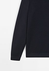 Marineblauw langsliepend shirt, gemaakt van zachte breimateriaal, met ribgebreide manchetten en een rechte zoom, met een gladde textuur en minimale details.