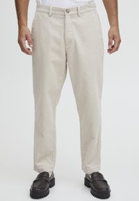 Beige corduroy trousers with vertical stripes, featuring a button closure, front pockets, and a straight cut design.