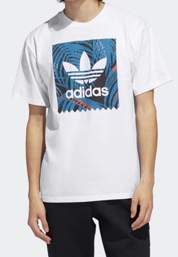 Vit bomull t-shirt med en färgglad grafik av Adidas-logotypen i blått och svart med abstrakta virvelmönster, rund halsringning och korta ärmar.