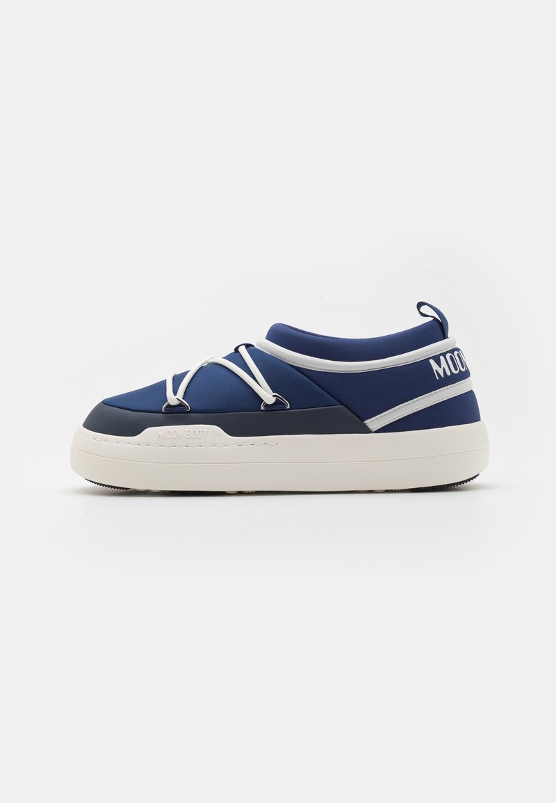 Zils ūdensizturīgs čības ar noapaļotu formu, baltiem šņorēm un kontrastējošām baltām akcentiem. Tekstūrēta gumijas zole ar redzamu protektora rakstu.