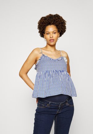 Top peplum riscado em azul e branco com decote franzido, alças finas e corte solto, combinado com jeans azul escuro.