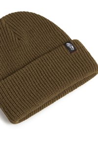 Brown knit beanie hat with a ribbed texture. Features a folded cuff and a small tag on the side displaying a logo.