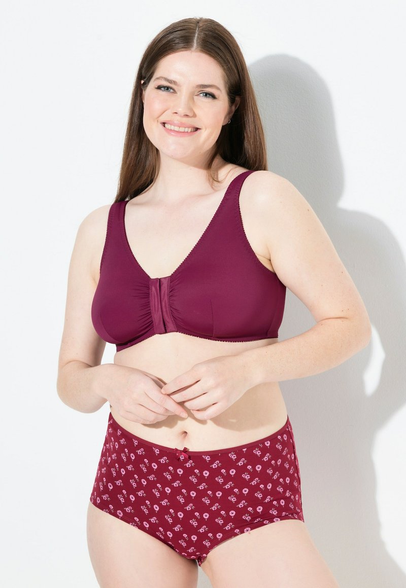 Soutien-gorge bordeaux avec un centre froncé et des bretelles larges, associé à des culottes taille haute assorties présentant un motif floral dans des teintes plus claires.